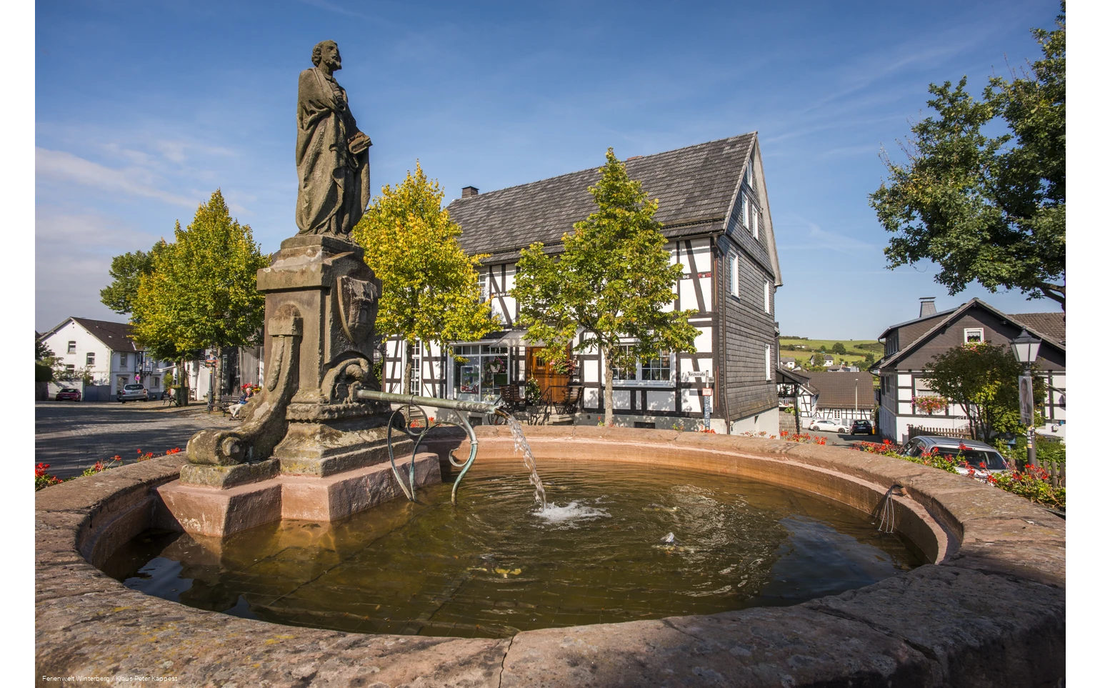 Brunnen umgeben von Fachwerkhäusern.