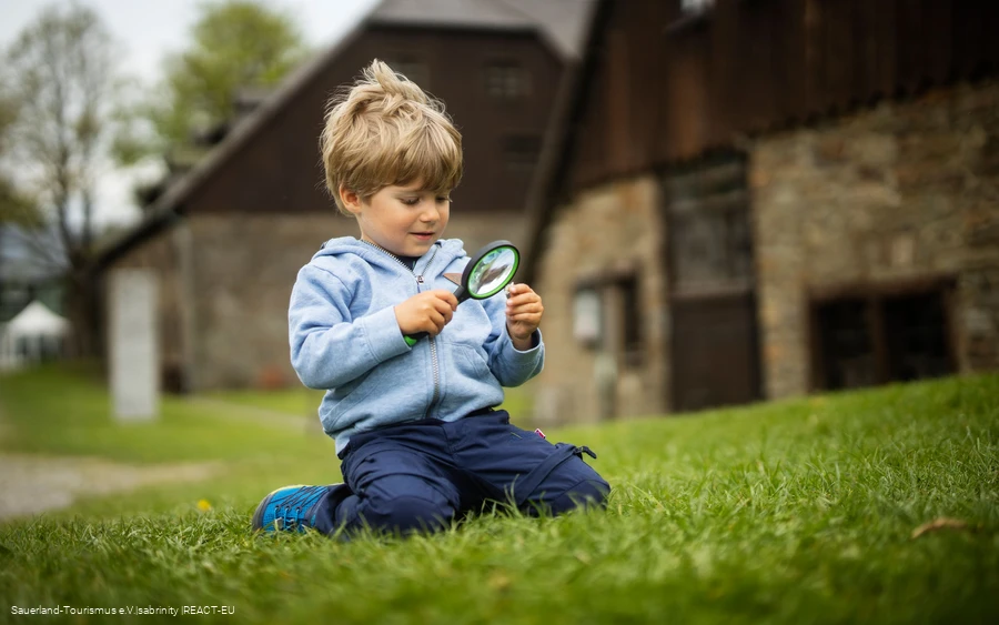 Kleinkind mit Lupe